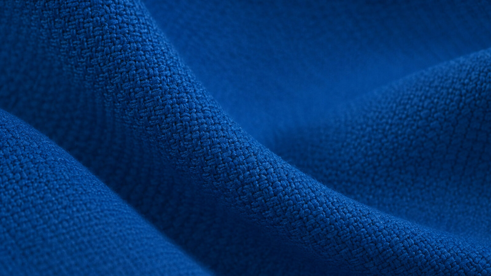 Close-up of folded blue fabric showing its textured weave and fibers Cargo.